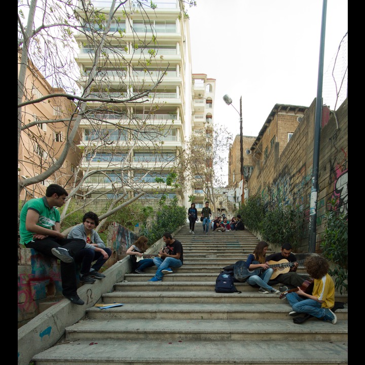 Students taking guitar lessons on the AUB stairs to Ain el Mraisseh