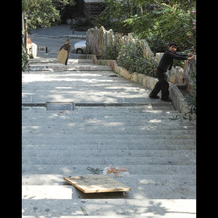 A lost childhood: the Syrian refugee shoe shine boys at play sliding on the AUB stairs with discarded peices of chipboard